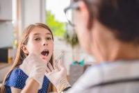 A provider takes a swab sample from a female child